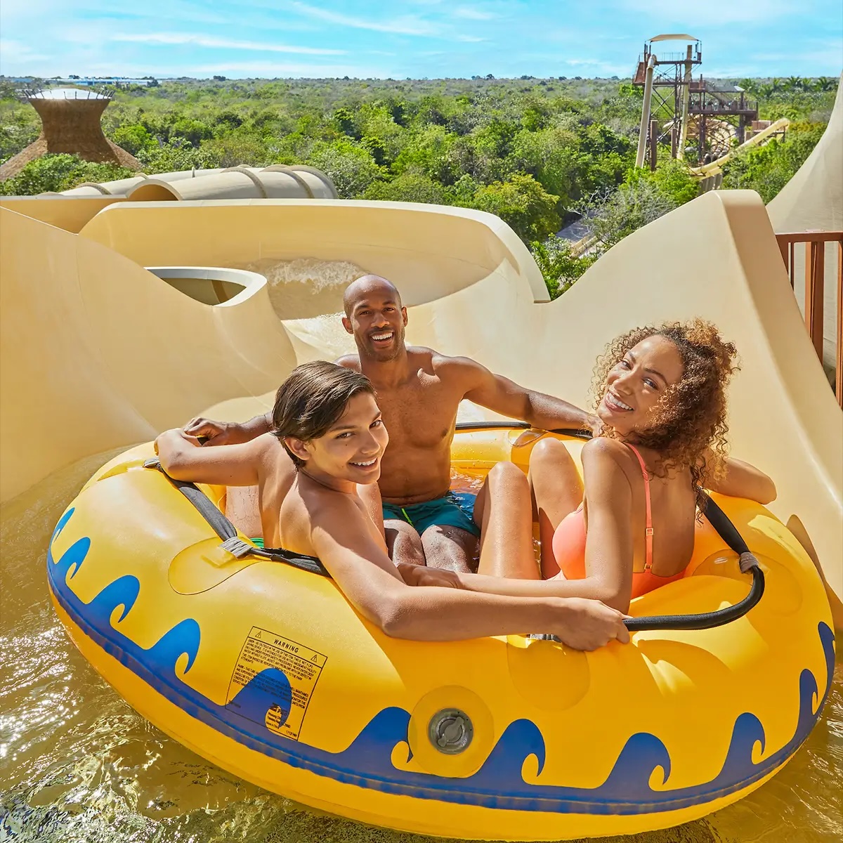 Family enjoying a raft water slide at the water park in Vidanta Riviera Maya